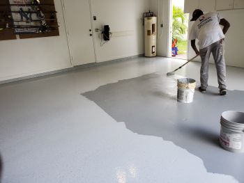 Painter painting garage floor.